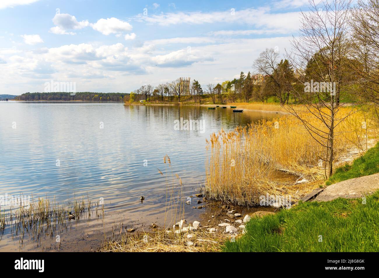 Vista panoramica dalla sorgente del lago Jezioro Elckie con canne e litorale boscoso lungo la passeggiata turistica nella città di Elk, nella regione di Masuria in Polonia Foto Stock