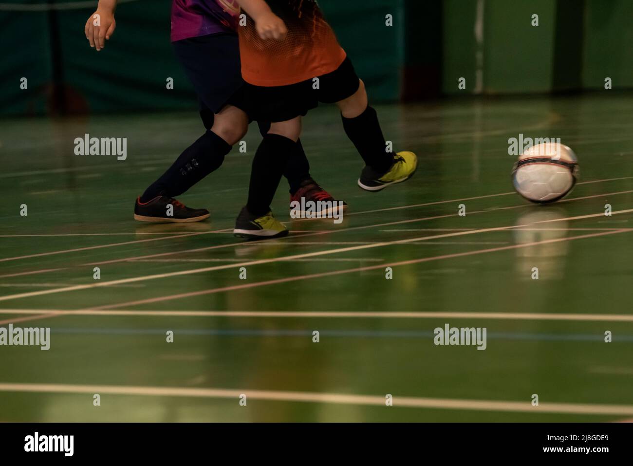 due bambini giocatori di calcio indoor combattono per il possesso della palla in spagna Foto Stock