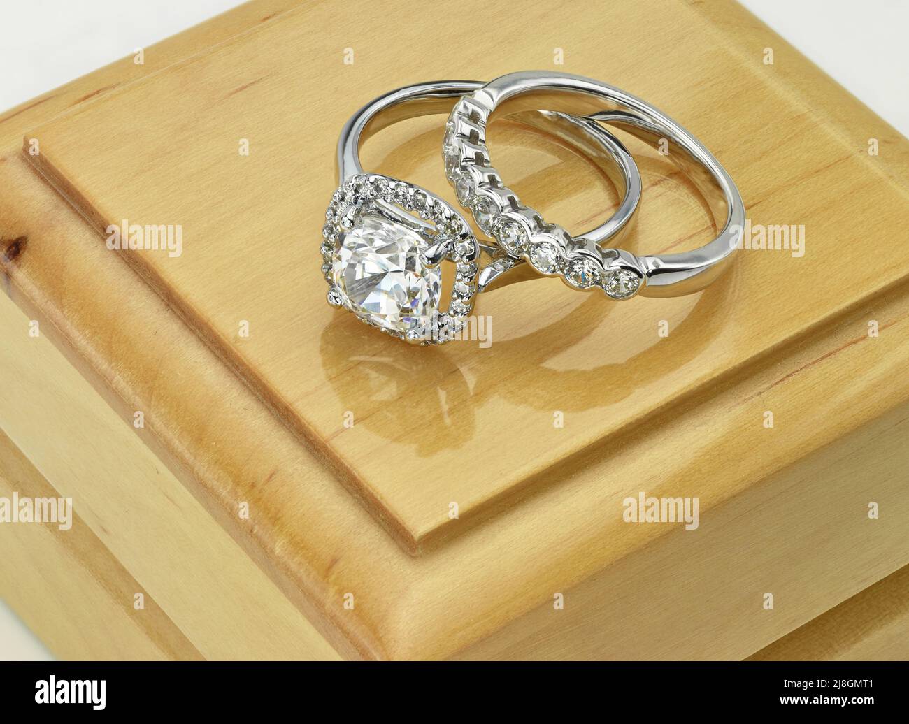 Set anello di fidanzamento e anello nuziale diamantato su scatola anello di legno Foto Stock