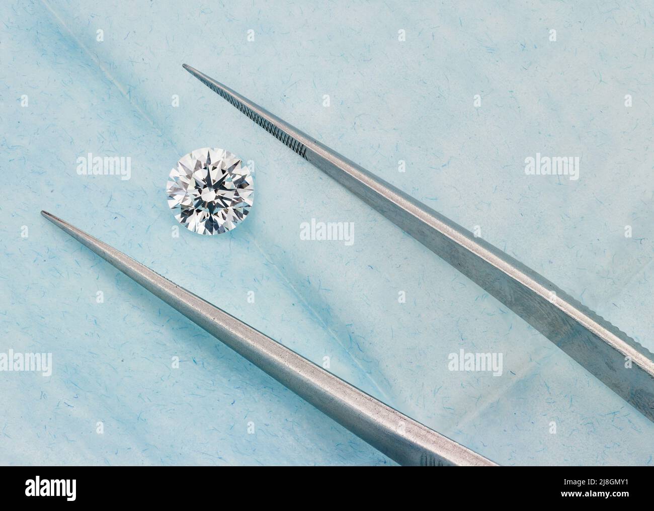 Diamante tondo tra pinzette in Blue Diamond Parcel Foto Stock