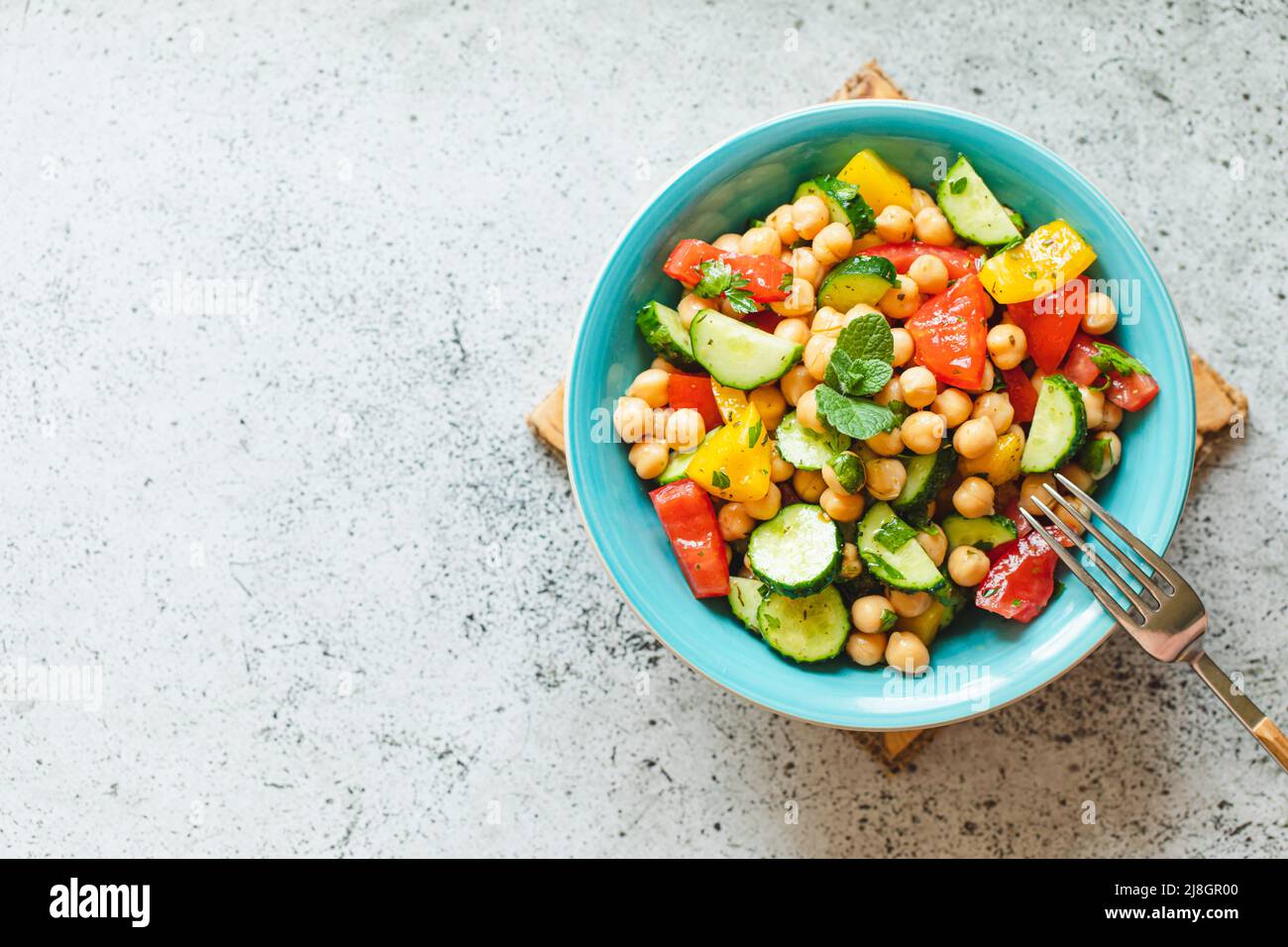 Insalata di ceci con pomodori, cetrioli, prezzemolo, cipolle in un piatto, fuoco selettivo. Cibo vegetariano sano, cucina orientale e mediterranea. Chic Foto Stock