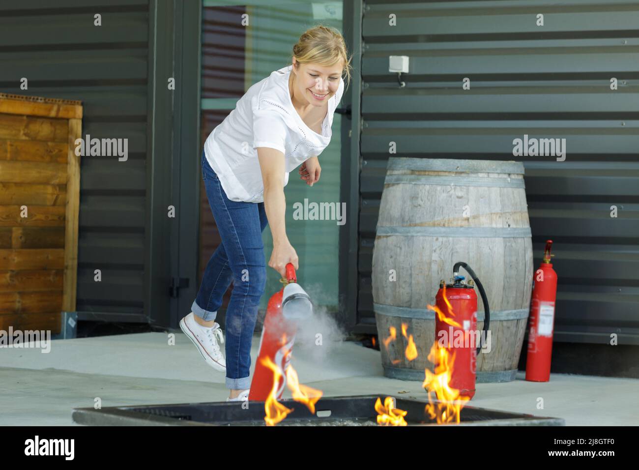 Donna di imparare a utilizzare l'estintore Foto Stock