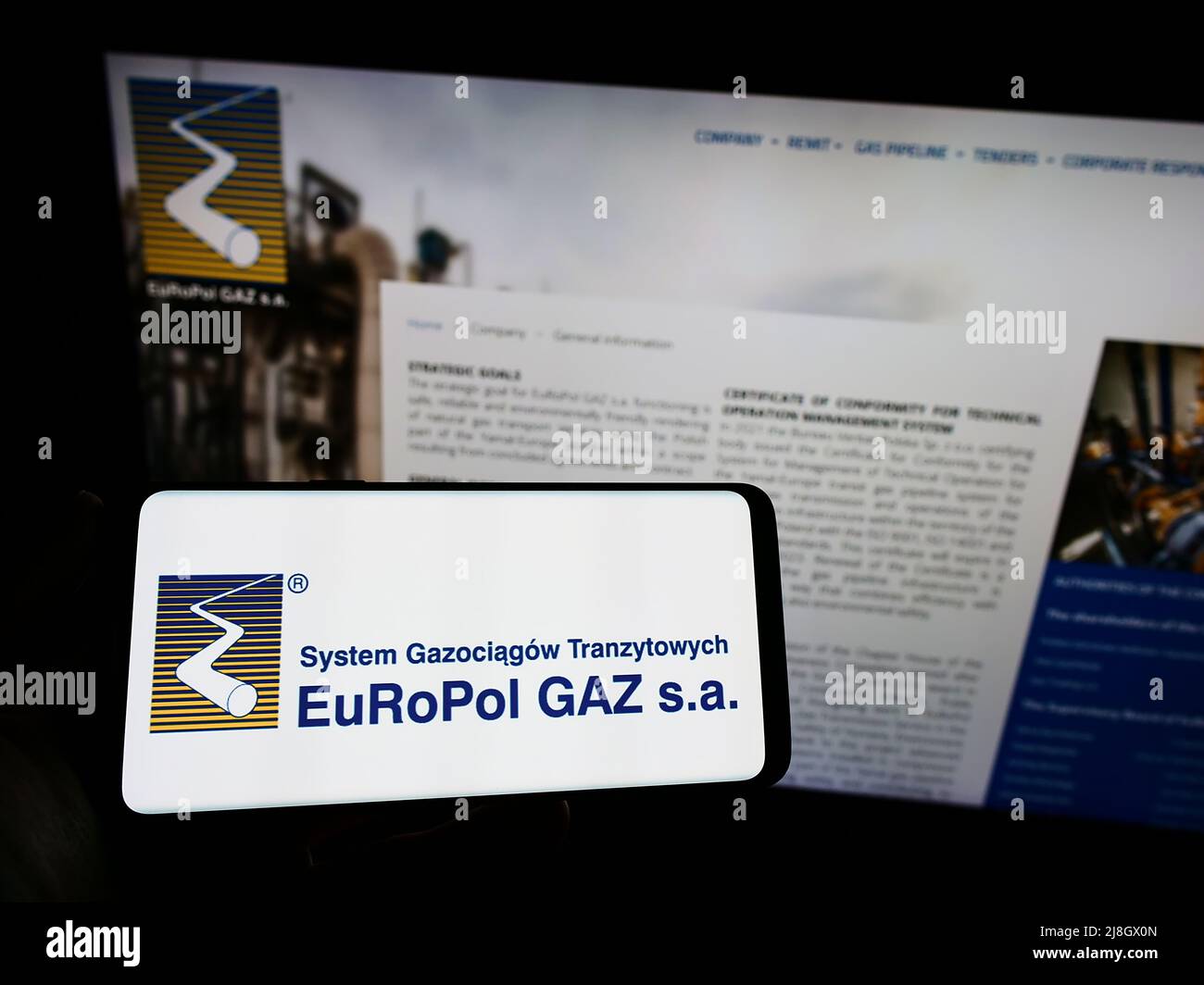Persona che tiene uno smartphone con il logo della società di gas polacca Europol GAZ s.a. sullo schermo di fronte al sito Web aziendale. Mettere a fuoco sul display del telefono. Foto Stock