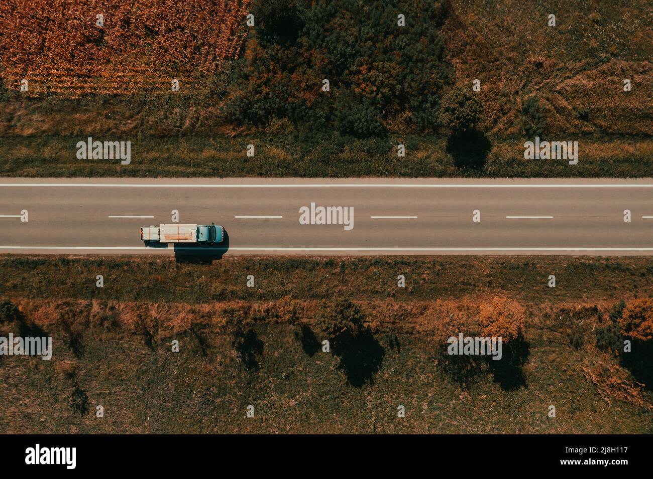 Vista aerea del camion che trasporta materiale da costruzione e tavole di legno su strada, fotografia con drone dall'alto verso il basso Foto Stock