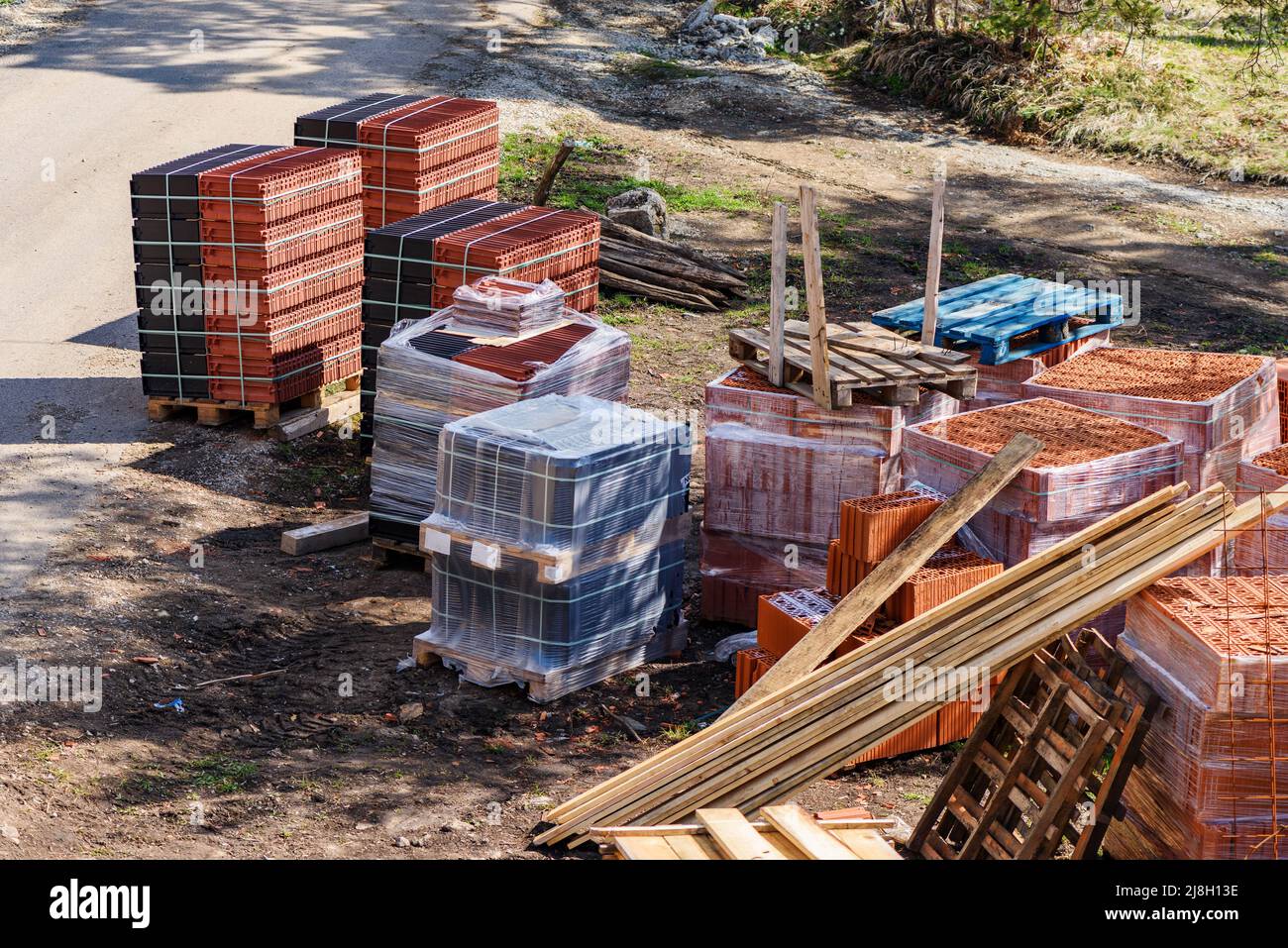 Materiale da costruzione in cantiere - assi, blocchi e tegole, vista ad angolo alto Foto Stock