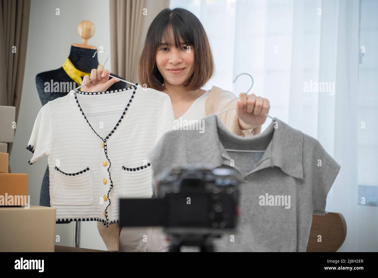 Giovane donna che lavora live streaming Online negozio di abbigliamento a casa. Foto Stock