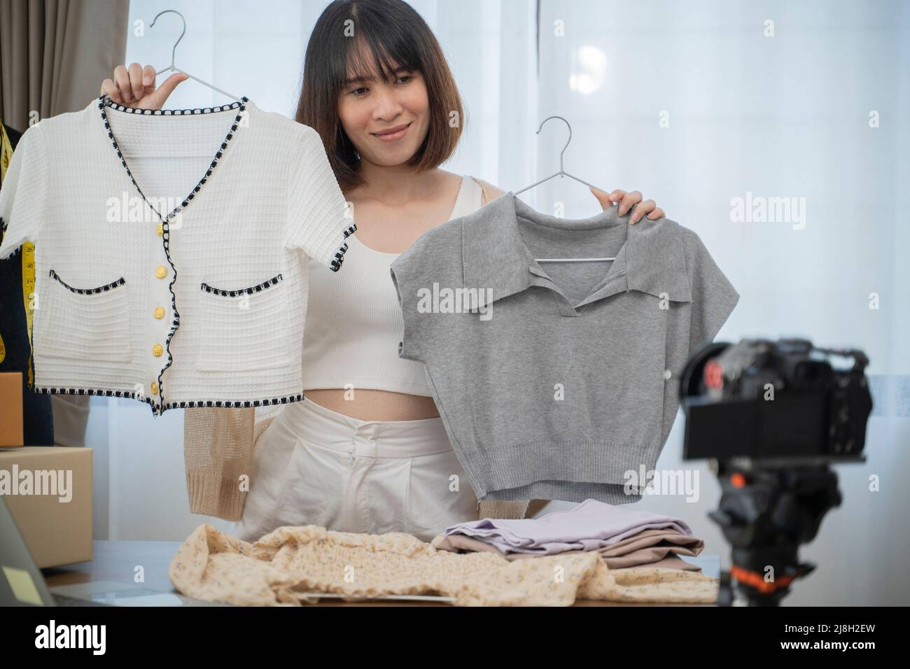 Giovane donna che lavora live streaming Online negozio di abbigliamento a casa. Foto Stock
