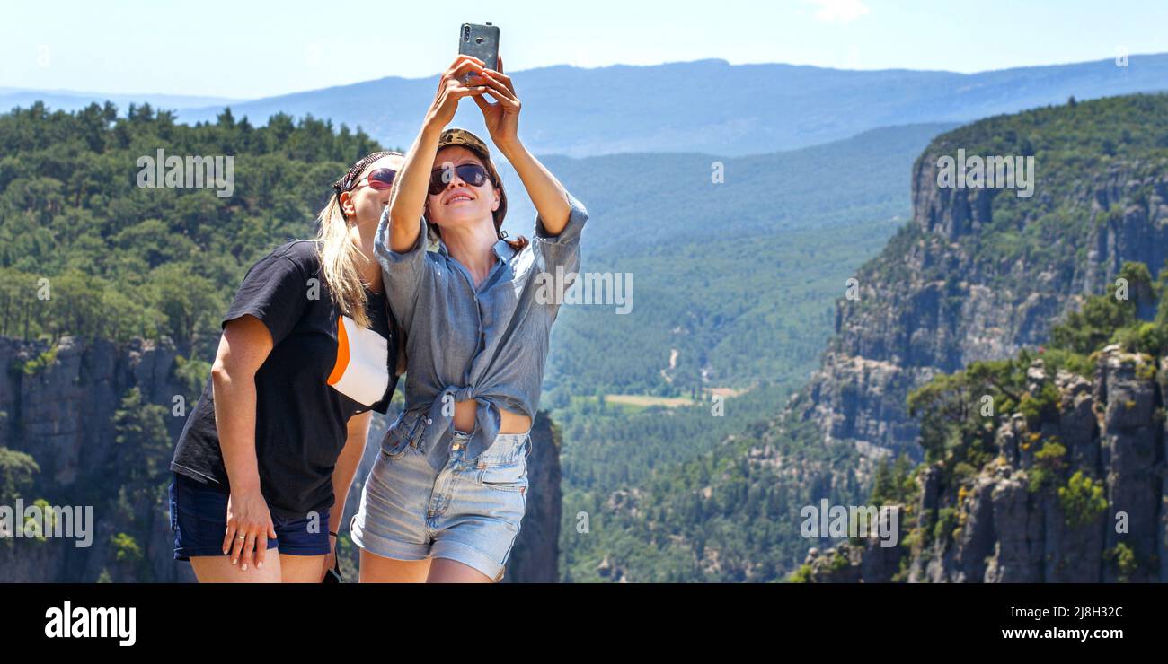 Il paesaggio del canyon di Tazi a Manavgat Turchia. Le ragazze felici prendono selfie sul pendio ripido. valle e scogliera Foto Stock