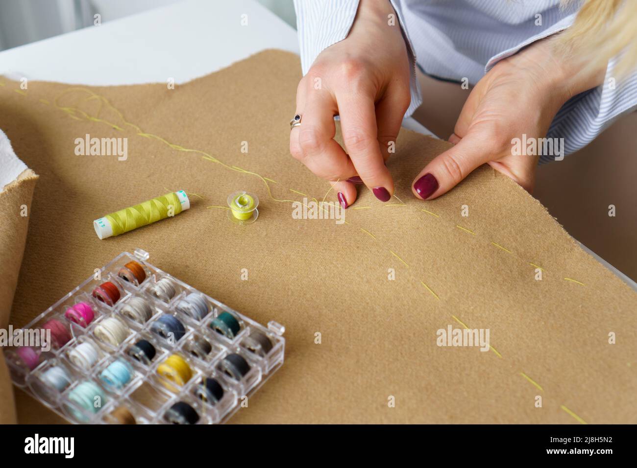 Su misura con l'ago in mani cuciti gli indumenti. Donna marinaio sul posto di lavoro. Ricamo per ricamo Foto Stock