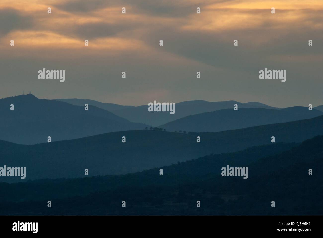Montagne al tramonto in un'ora blu con nuvole dai toni freddi Foto Stock Montagne al tramonto in un'ora blu con nuvole dai toni freddi Foto Stock