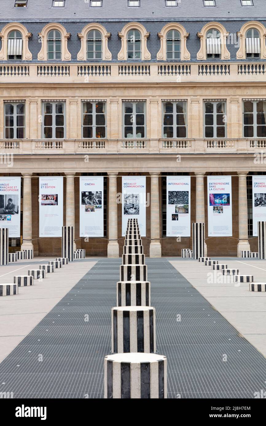 Installazione d'arte di Daniel Buren - Les Deux Plateais e poster che celebrano i 60 anni del Ministero dell'Arte e della Cultura - Palais Royal, Parigi, Foto Stock