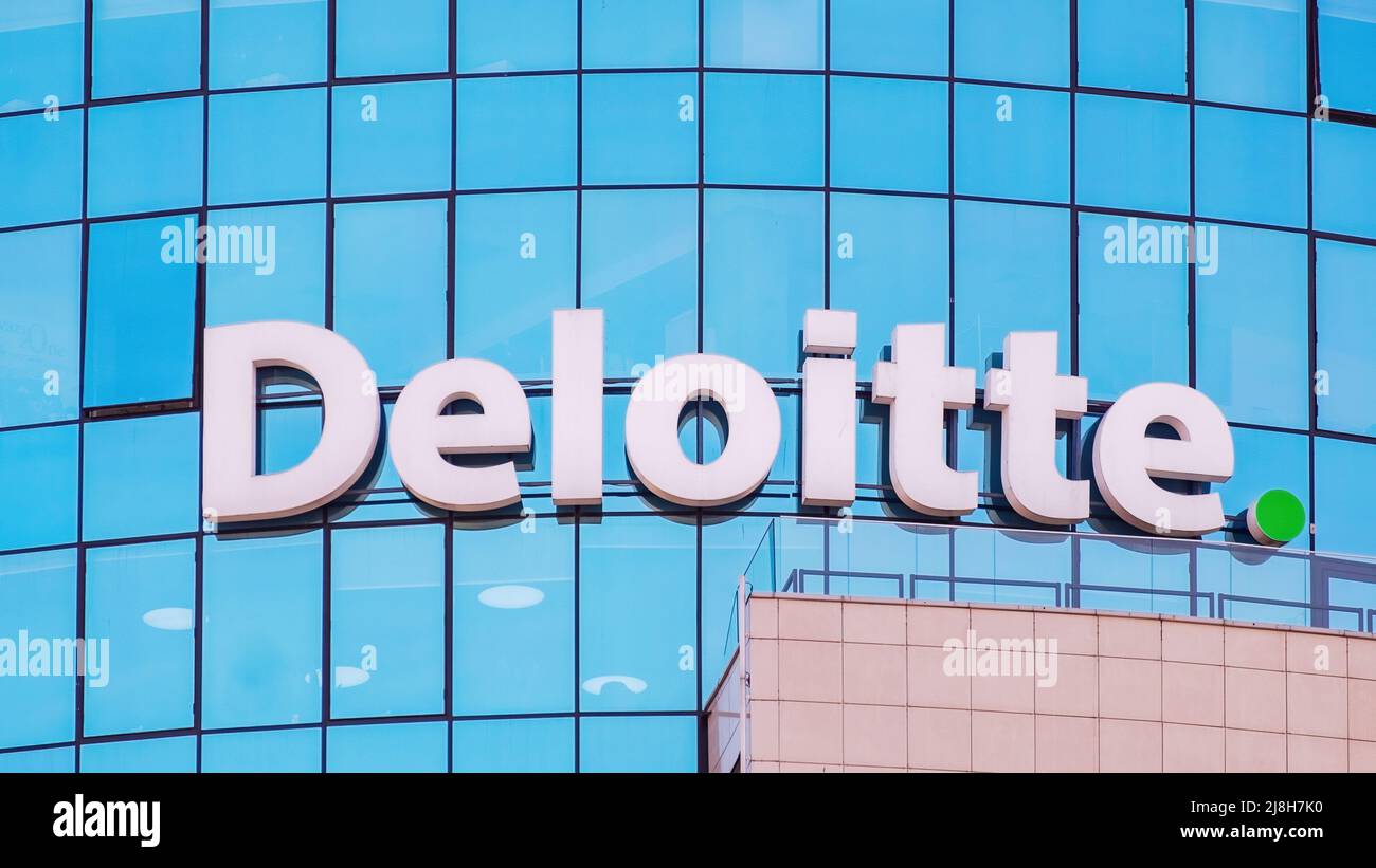 Deloitte segno sulla facciata di vetro di un edificio di uffici Foto Stock