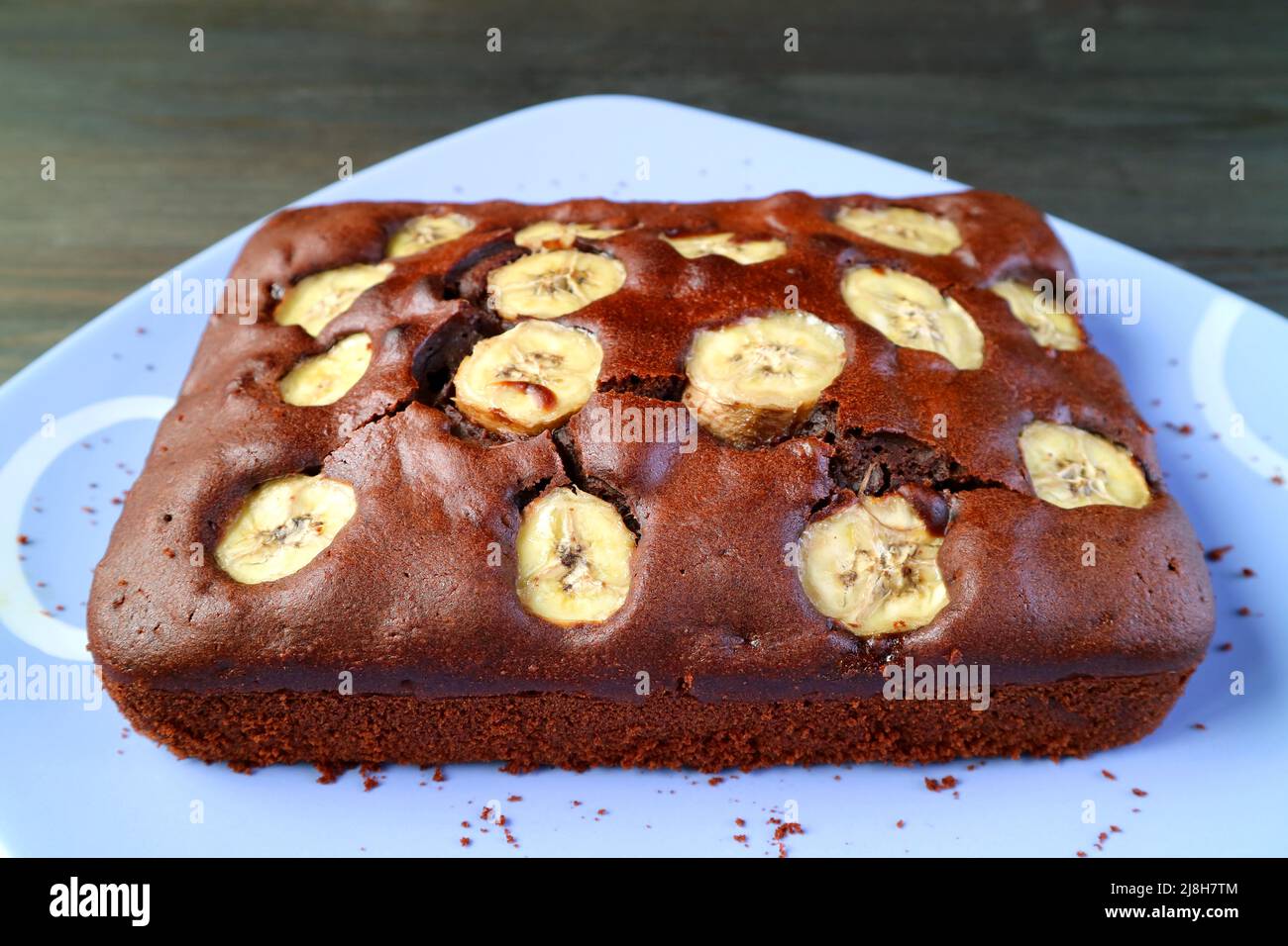 Torta di Banana al cioccolato integrale fatta in casa al forno fresco su un piatto blu Foto Stock