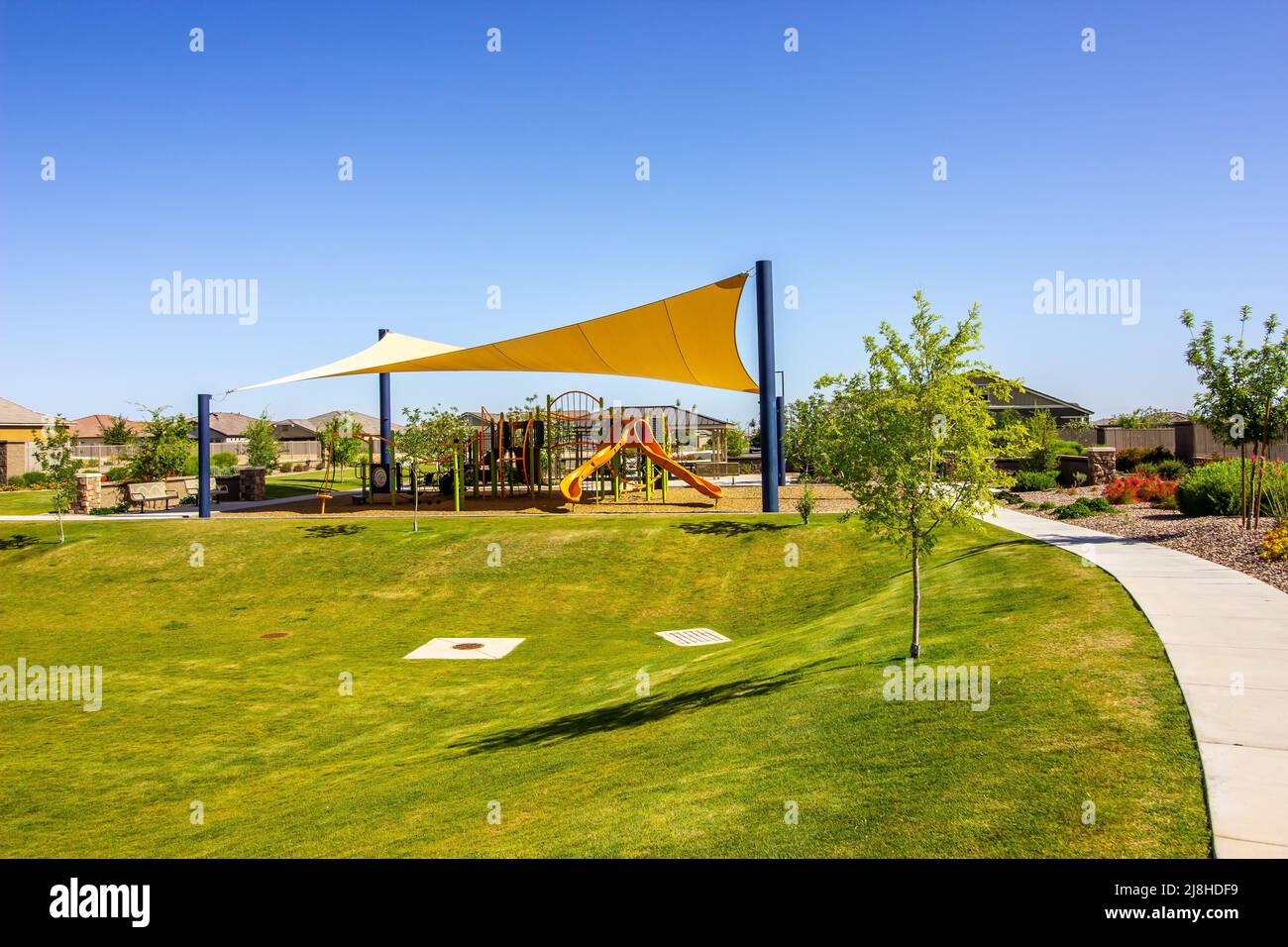 Sviluppo dell'alloggiamento con il parco giochi Jungle Gym sotto la tettoia dell'ombra Foto Stock