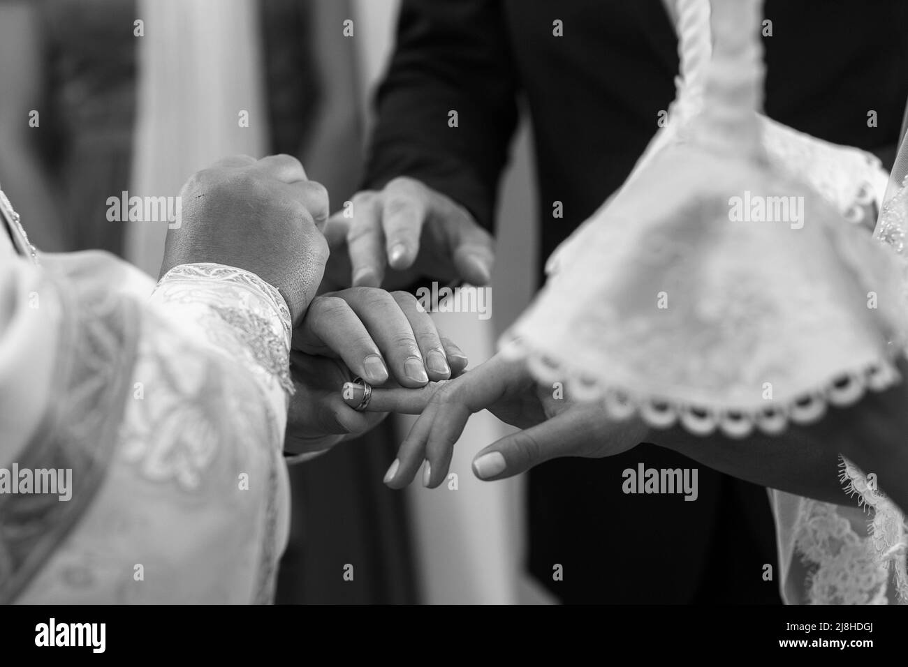 Il sacerdote nella chiesa mette gli anelli sulla sposa e lo sposo. Foto Stock