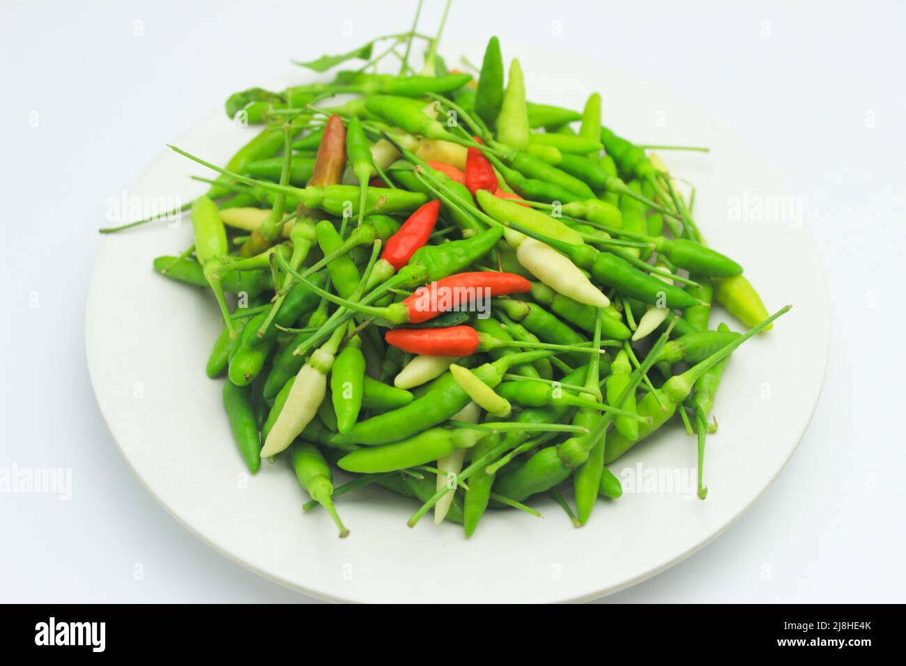 Peperoni. Mucchio di peperoncini rossi e verdi freschi isolati su sfondo bianco Foto Stock