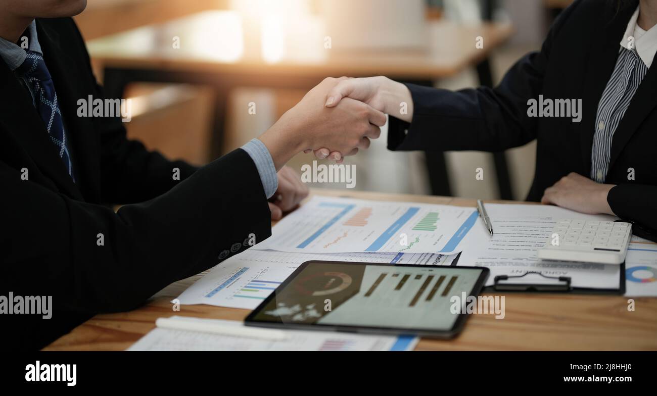 Due uomini d'affari scuotono le mani dopo aver accettato una proposta di business insieme, una stretta di mano è un omaggio universale, spesso utilizzato nel saluto o. Foto Stock