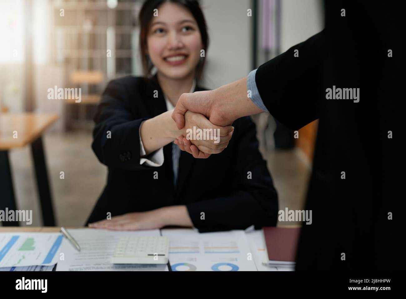 Due uomini d'affari scuotono le mani dopo aver accettato una proposta di business insieme, una stretta di mano è un omaggio universale, spesso utilizzato nel saluto o. Foto Stock