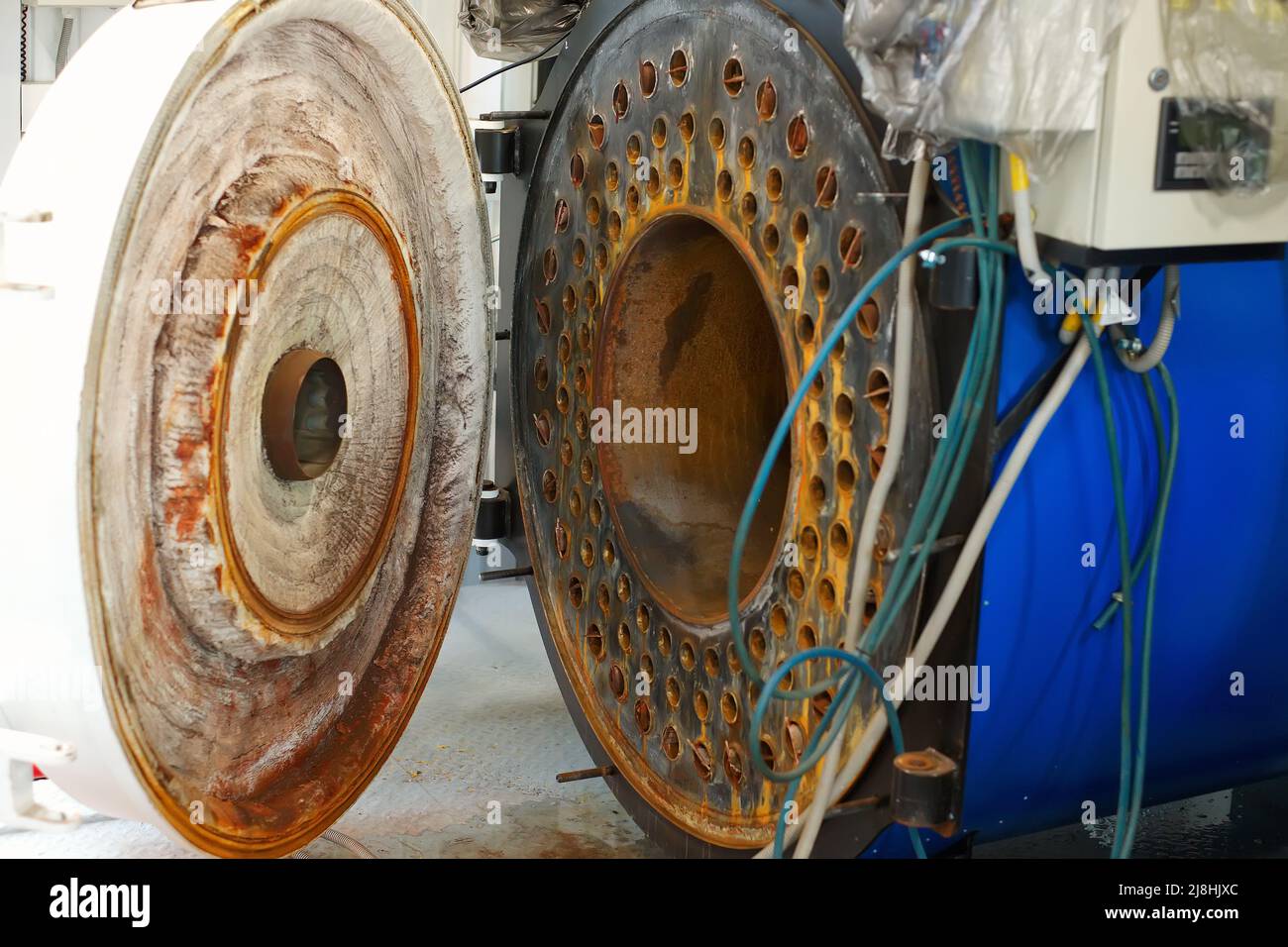 Vista della caldaia a gas aperta. Riparazione e manutenzione di apparecchiature industriali. Preparazione del locale caldaia per la stagione di riscaldamento. Sfondo Foto Stock