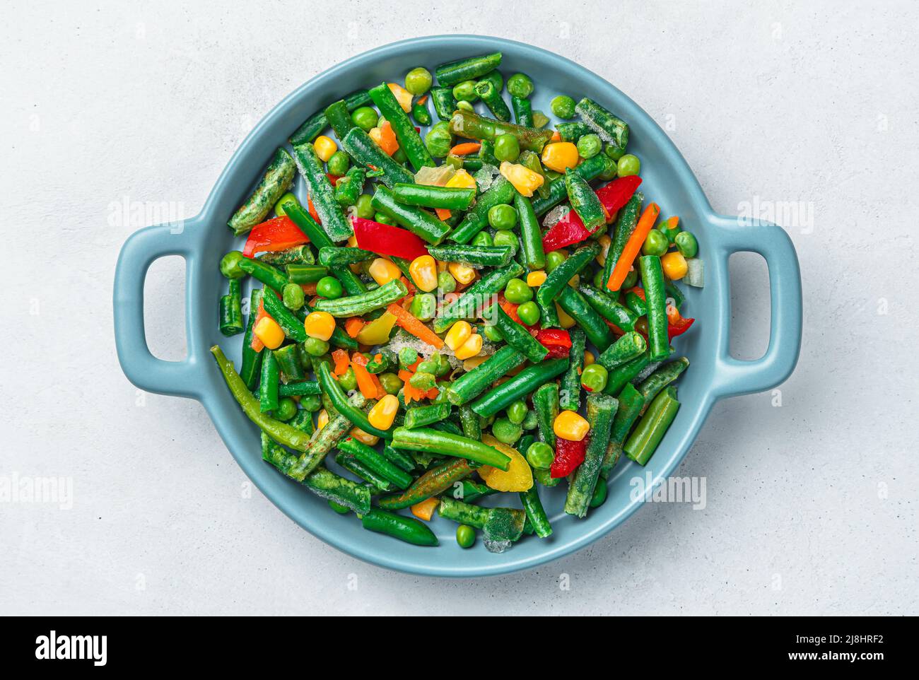 Miscela vegetale surgelata su sfondo grigio. Cucina. Foto Stock