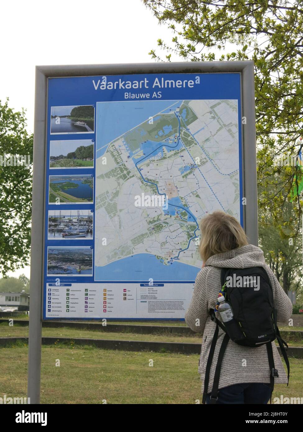 I turisti con zaino fermano a guardare una mappa di informazioni presso il porto di Almere Haven, Flevoland, Paesi Bassi. Foto Stock