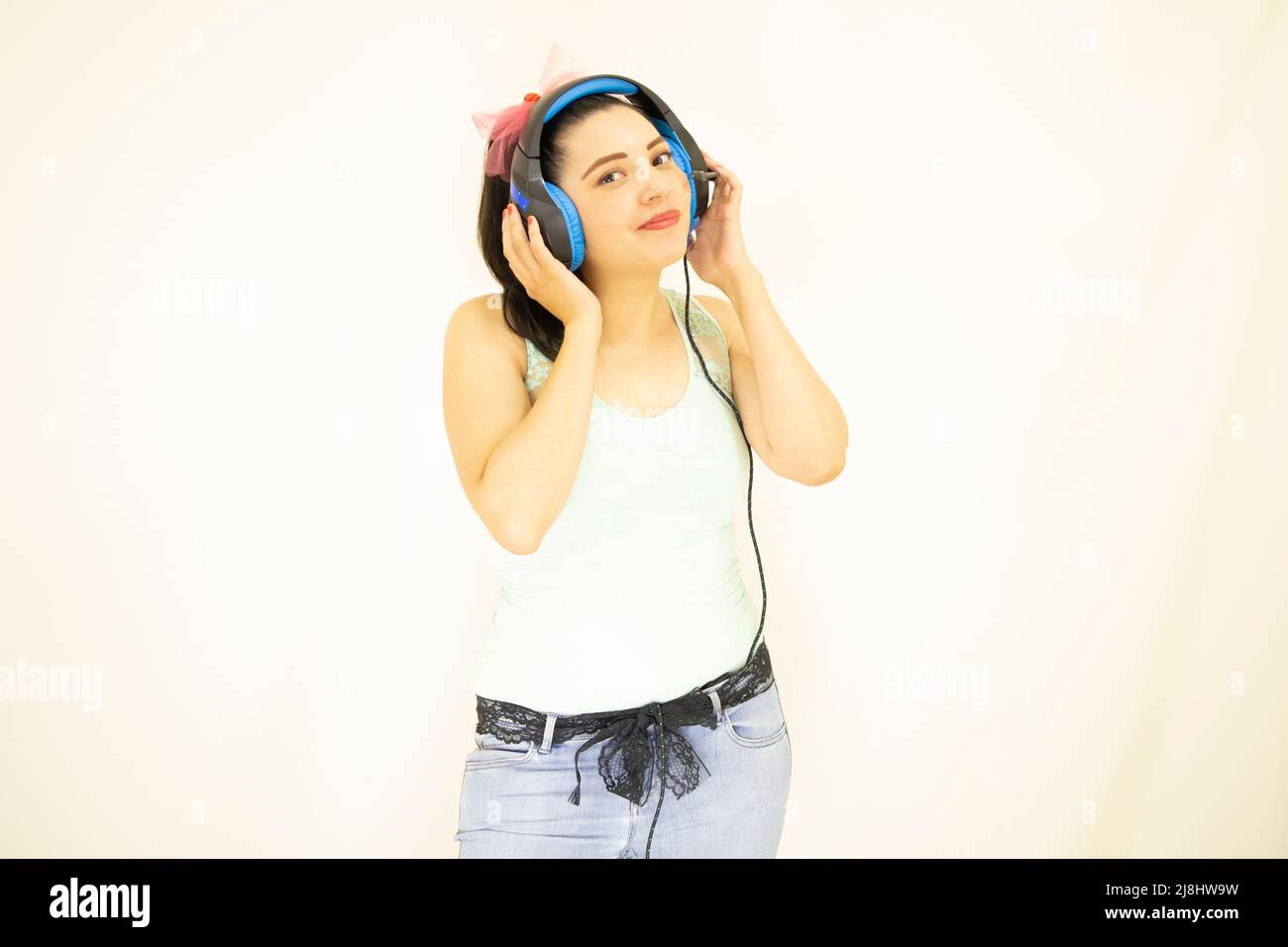 giovane bella studentessa che ascolta la musica con le cuffie blu Foto Stock