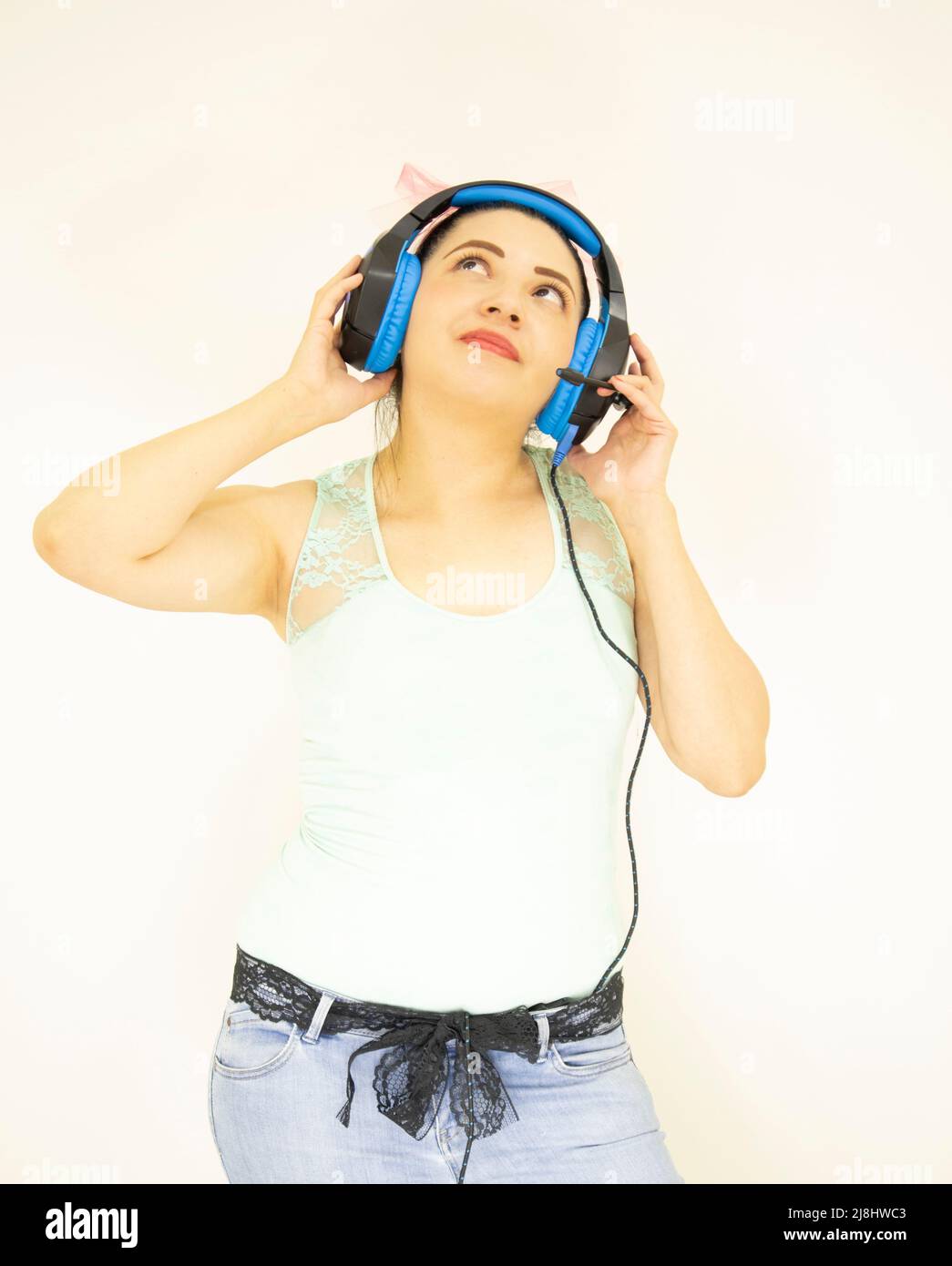 giovane bella studentessa che ascolta la musica con le cuffie blu Foto Stock