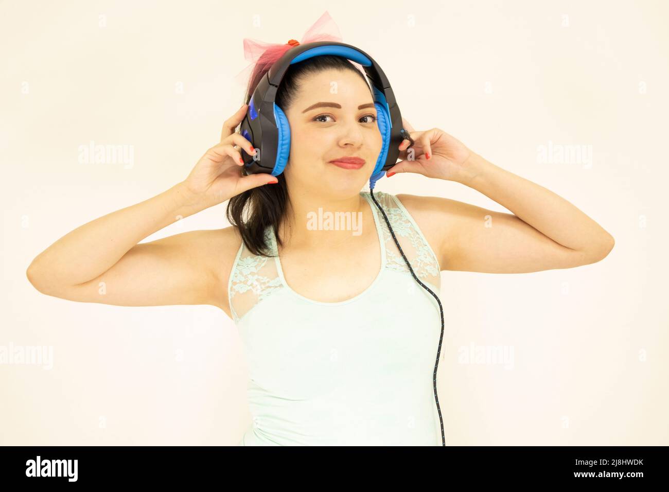 giovane bella studentessa che ascolta la musica con le cuffie blu Foto Stock