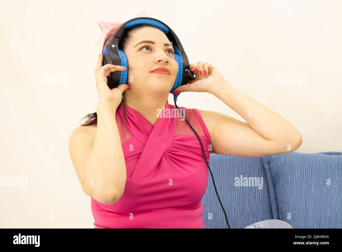 giovane bella studentessa che ascolta la musica con le cuffie blu Foto Stock