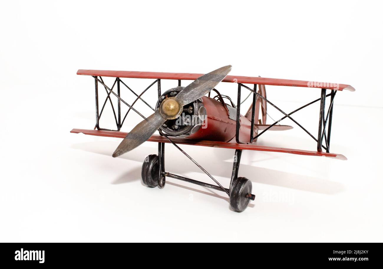 Angolo anteriore del giocattolo dell'aeromobile biplanare rosso su sfondo bianco. Aereo, aereo, elica, aereo, aviazione Foto Stock