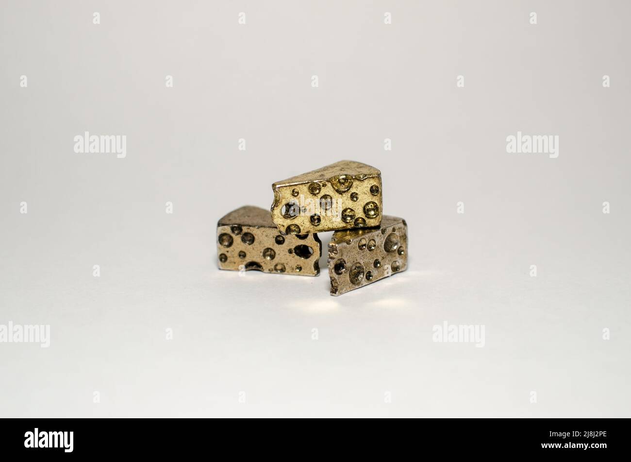 Tre spicchi di formaggio svizzero - Miniature Gold Metal Pewter Collectable Figurine, in Center on Plain background Foto Stock