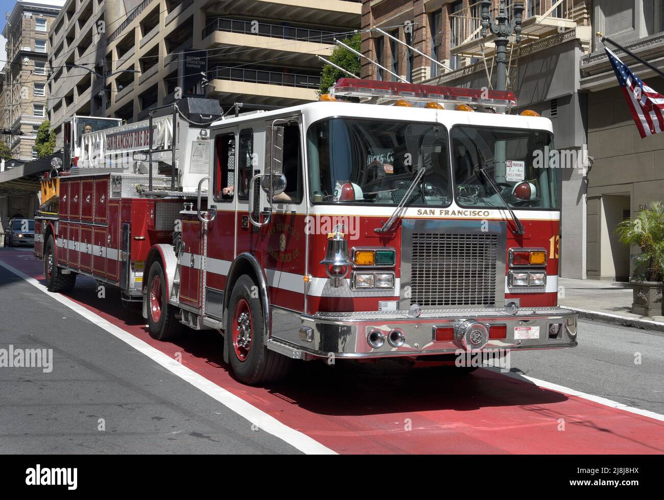 Un camion del fuoco del timone con le ruote sterzanti sia la parte anteriore che la parte posteriore si muove lungo una strada a San Francisco, California. Un tillerman siede nella parte posteriore. Foto Stock