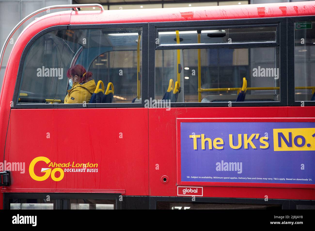 I passeggeri, alcuni che indossano una maschera e altri no, sono visti in un autobus a due piani nella City of London. Foto Stock