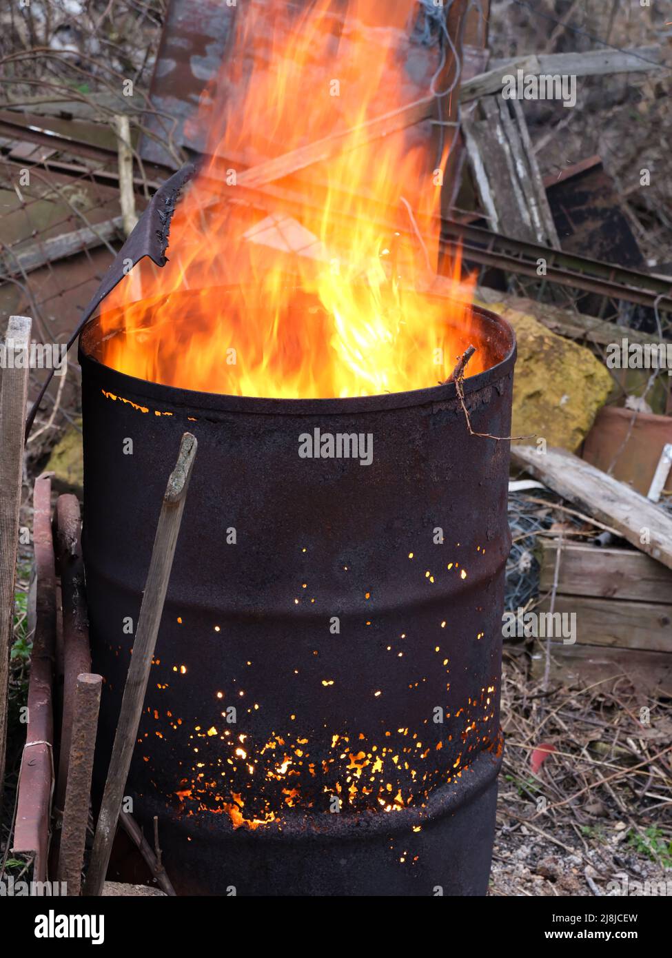 Fuoco luminoso che brucia all'interno di un vecchio barile arrugginito  all'aperto Foto stock - Alamy