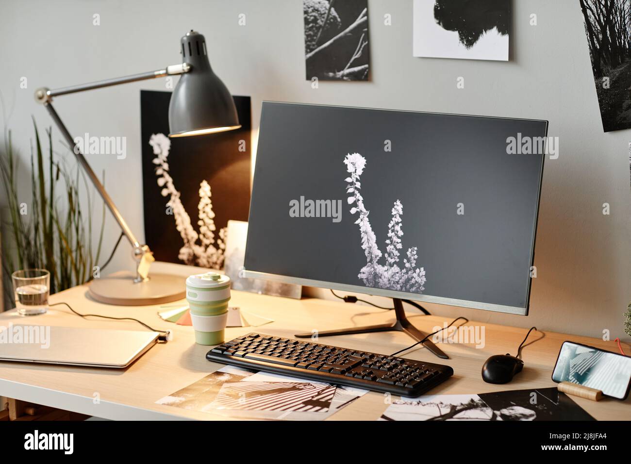 Immagine di sfondo del luogo di lavoro degli editori con foto in bianco e nero minime sullo schermo del computer Foto Stock