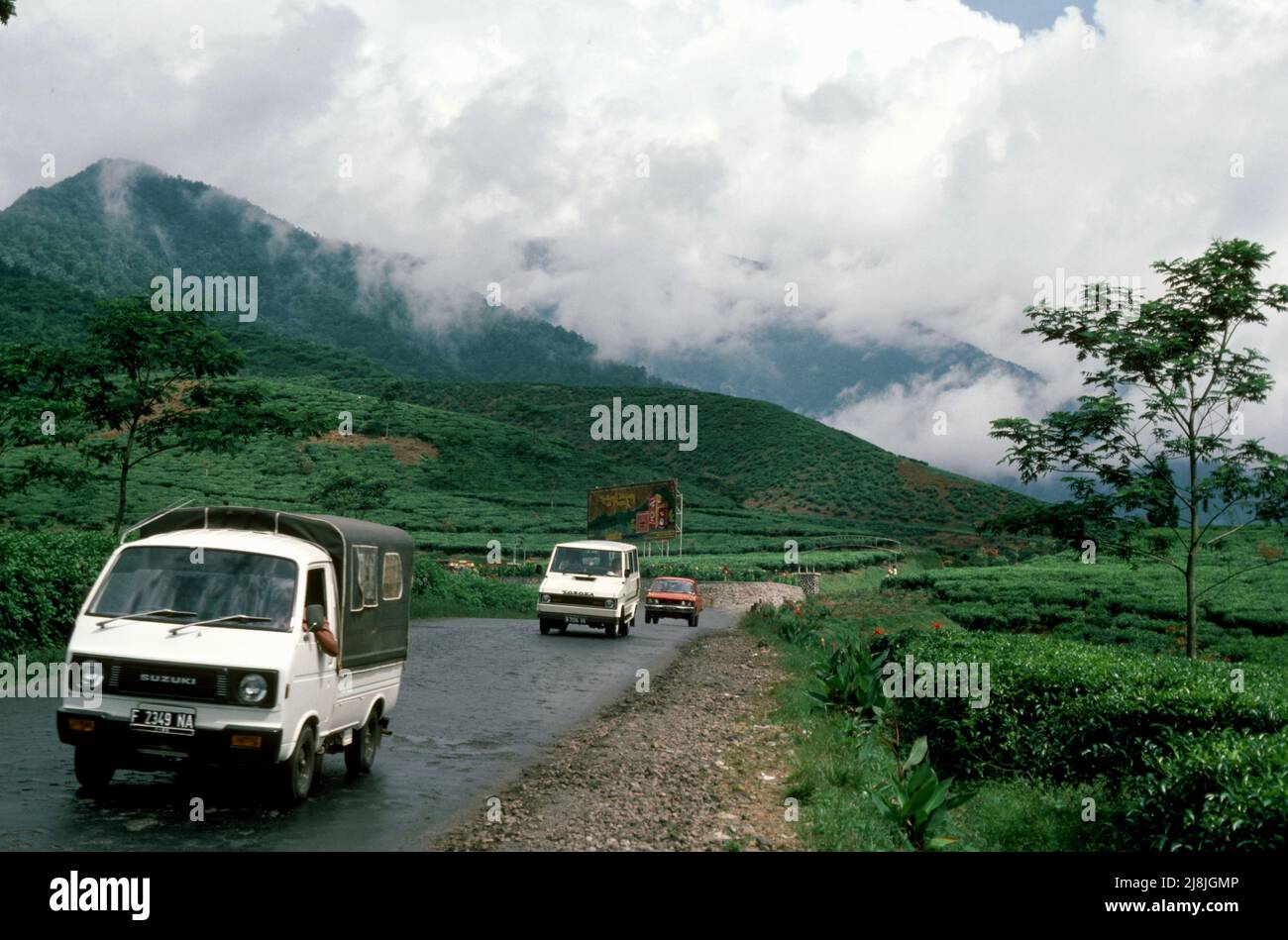 Auto su strada che attraversano piantagioni di tè a Puncak a sud di Giacarta, Indonesia 1984 Foto Stock