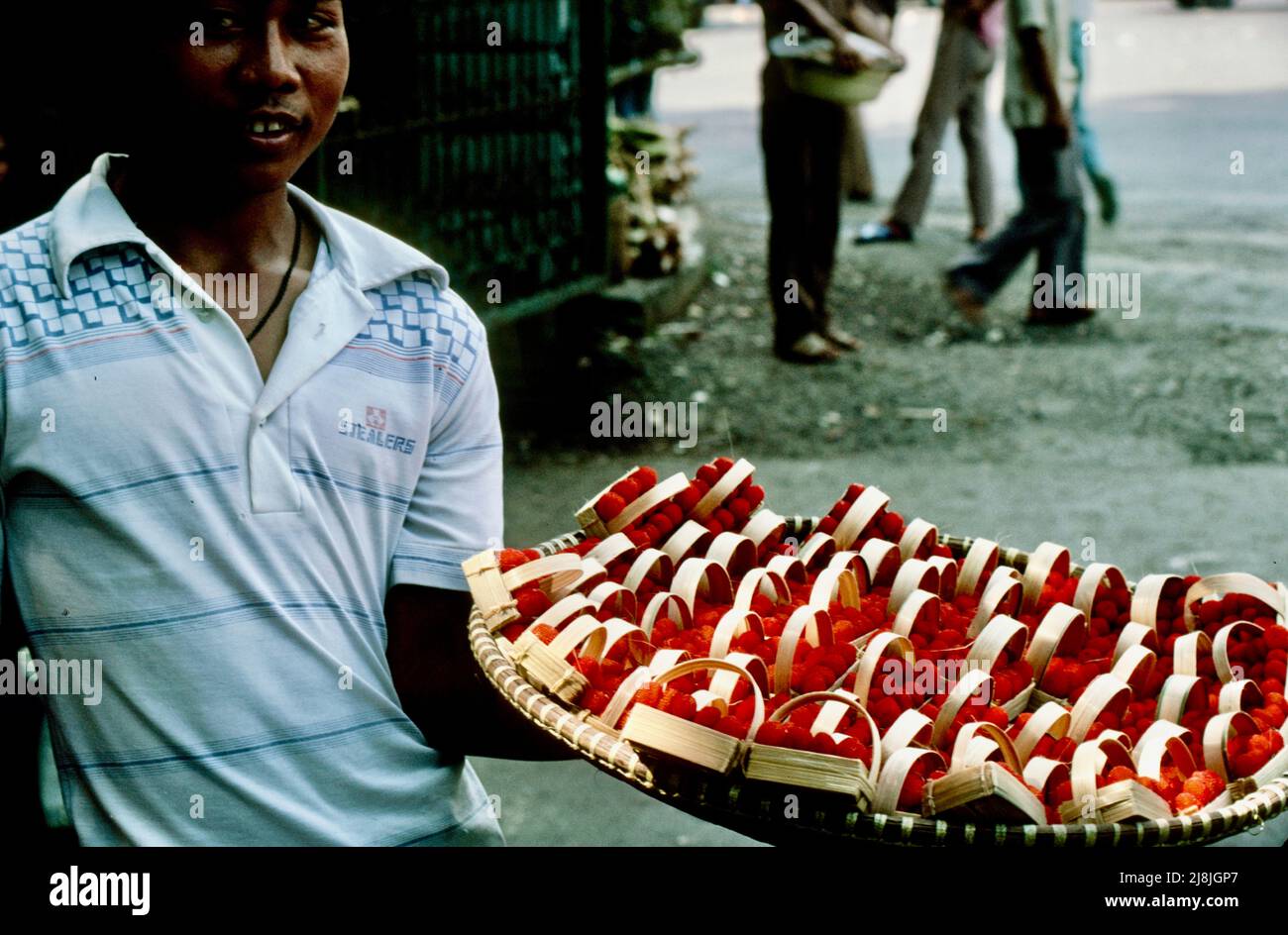 Uomo che vende fragole selvatiche a Bogor, Indonesia 1984 Foto Stock