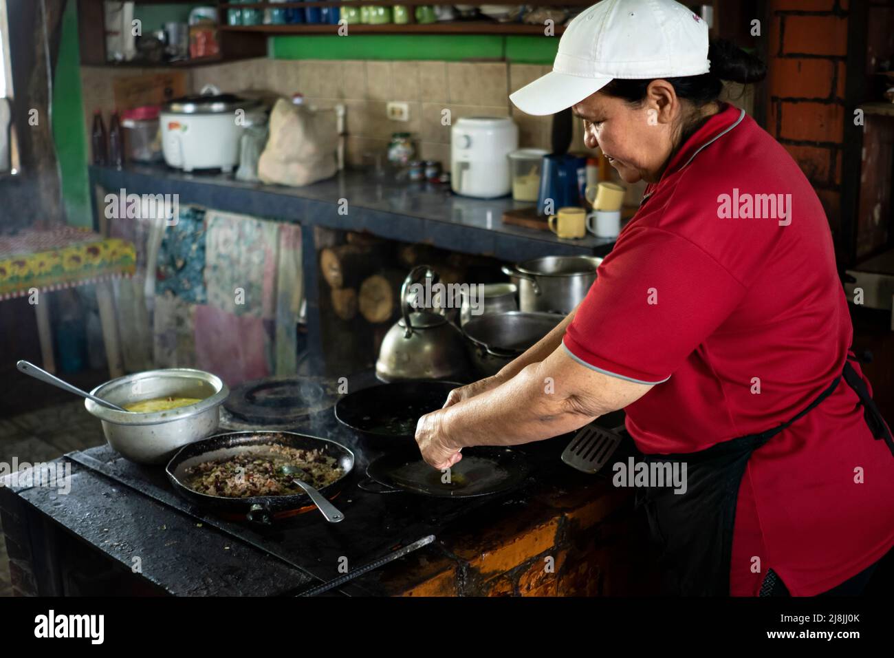 Donna che si concentra sulla cucina nel suo piccolo Costa Rica tipico alimentare business. Foto Stock
