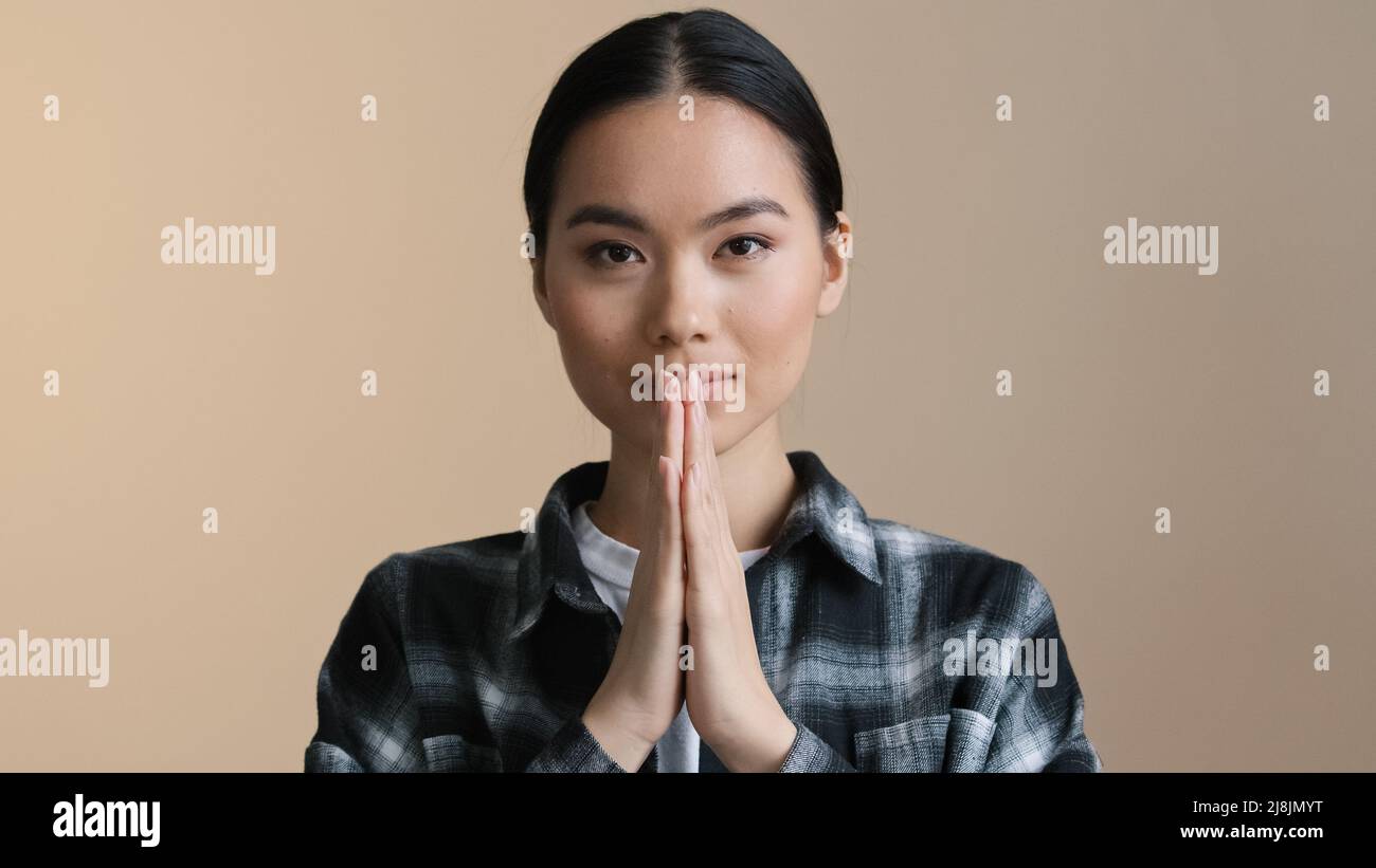 Primo piano ritratto asiatico calma ragazza piega palme di fronte archi namaste saluto preghiera. Donna coreana giapponese donna cinese che chiede perdono scuse Foto Stock