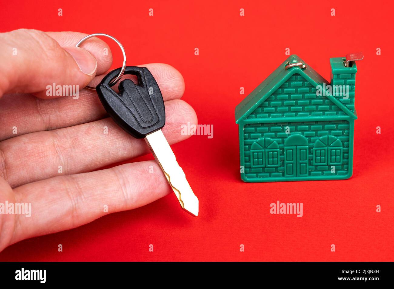 mano dell'uomo che tiene la chiave alla casa, e un modello della casa Foto Stock