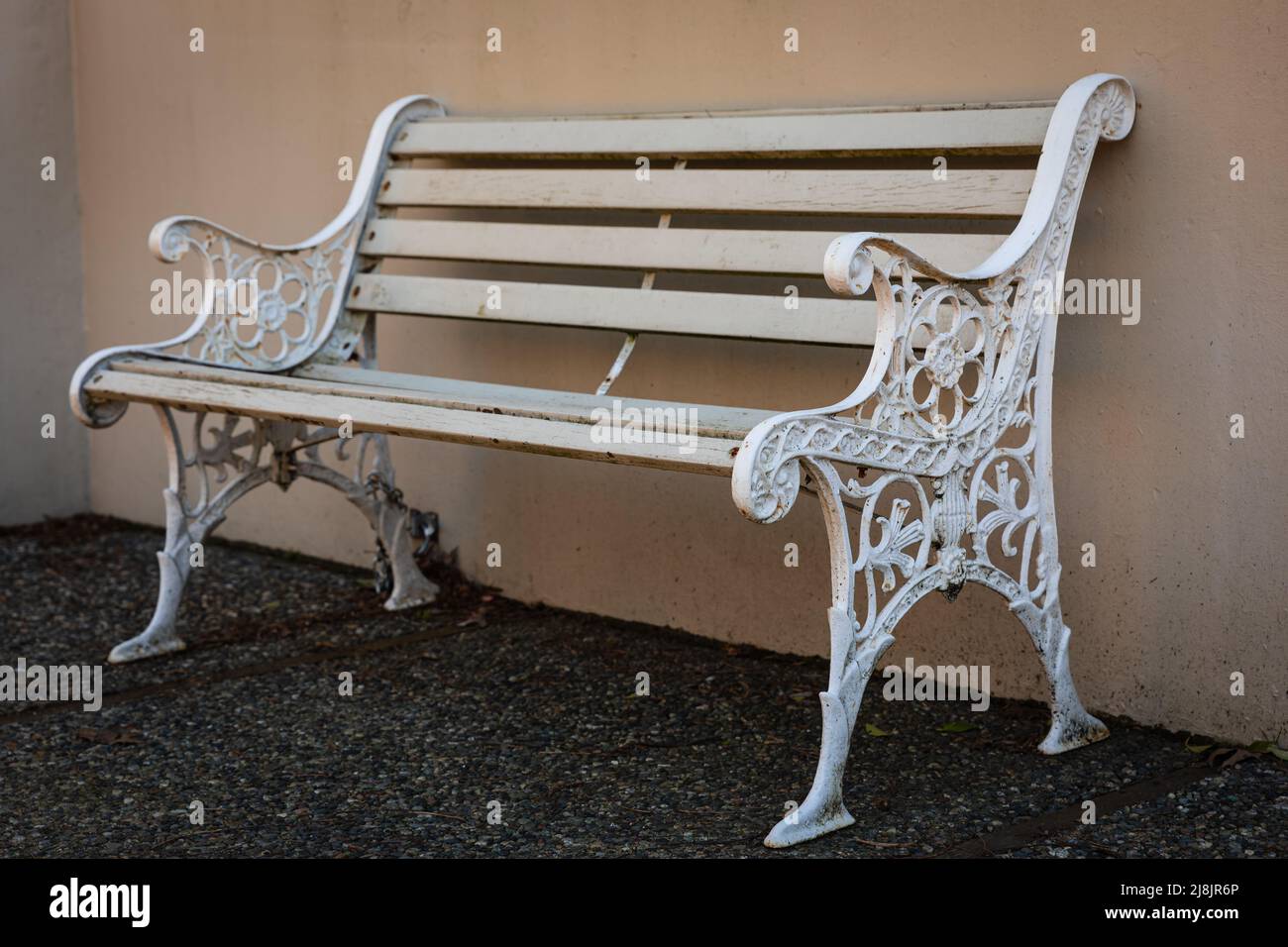 Vista laterale di una panca in legno bianco con gambe lavorate con motivi ornamentali. Foto Stock