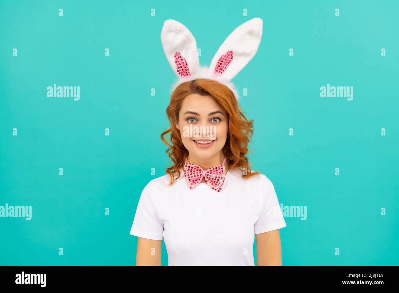 felice sorridente pasqua donna in coniglietto orecchie e fiocco cravatta su sfondo blu Foto Stock