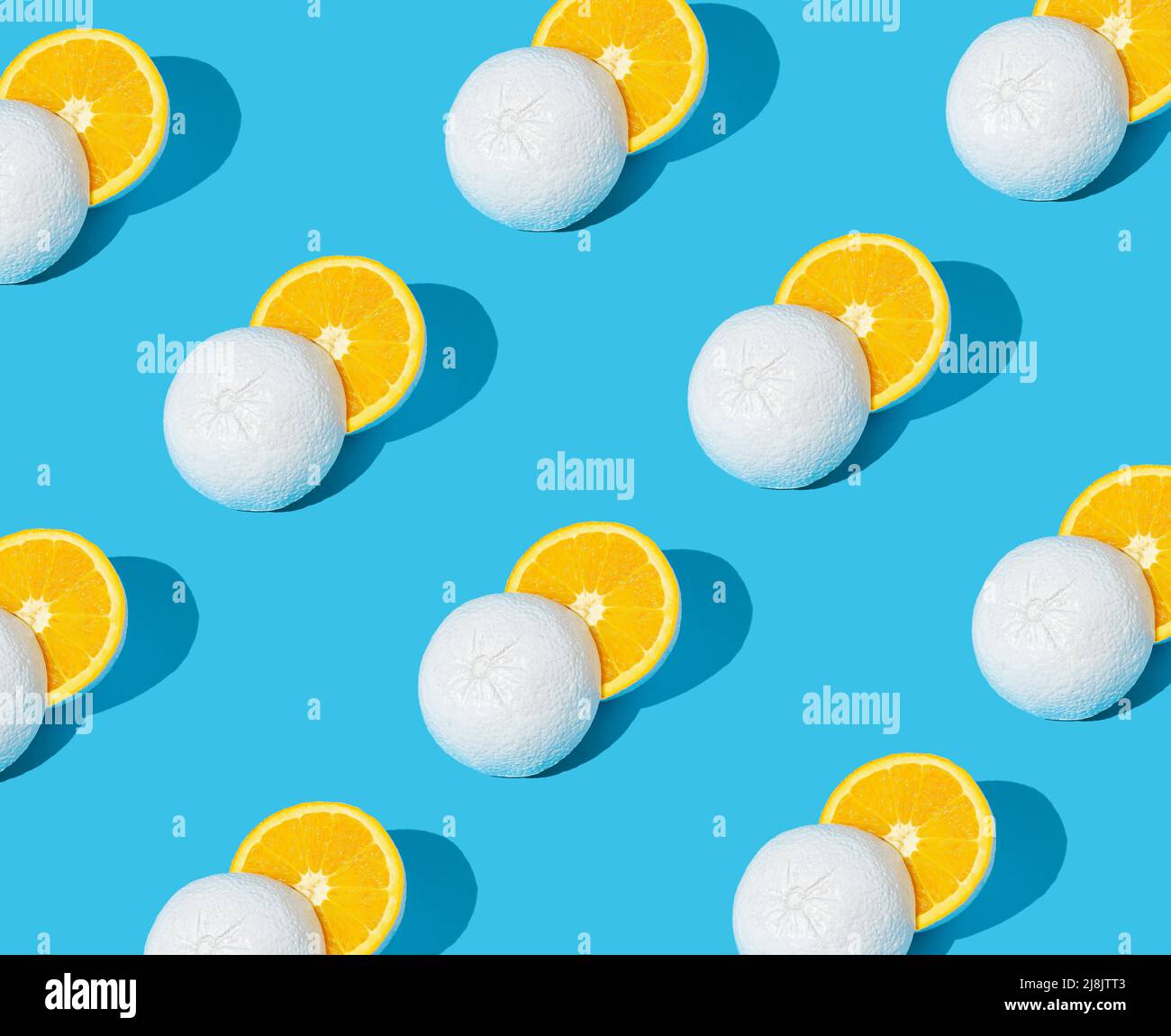 Motivo fatto di pompelmo giallo dipinto di bianco tagliato a metà su sfondo blu pastello. Concetto estivo minimo. Foto Stock