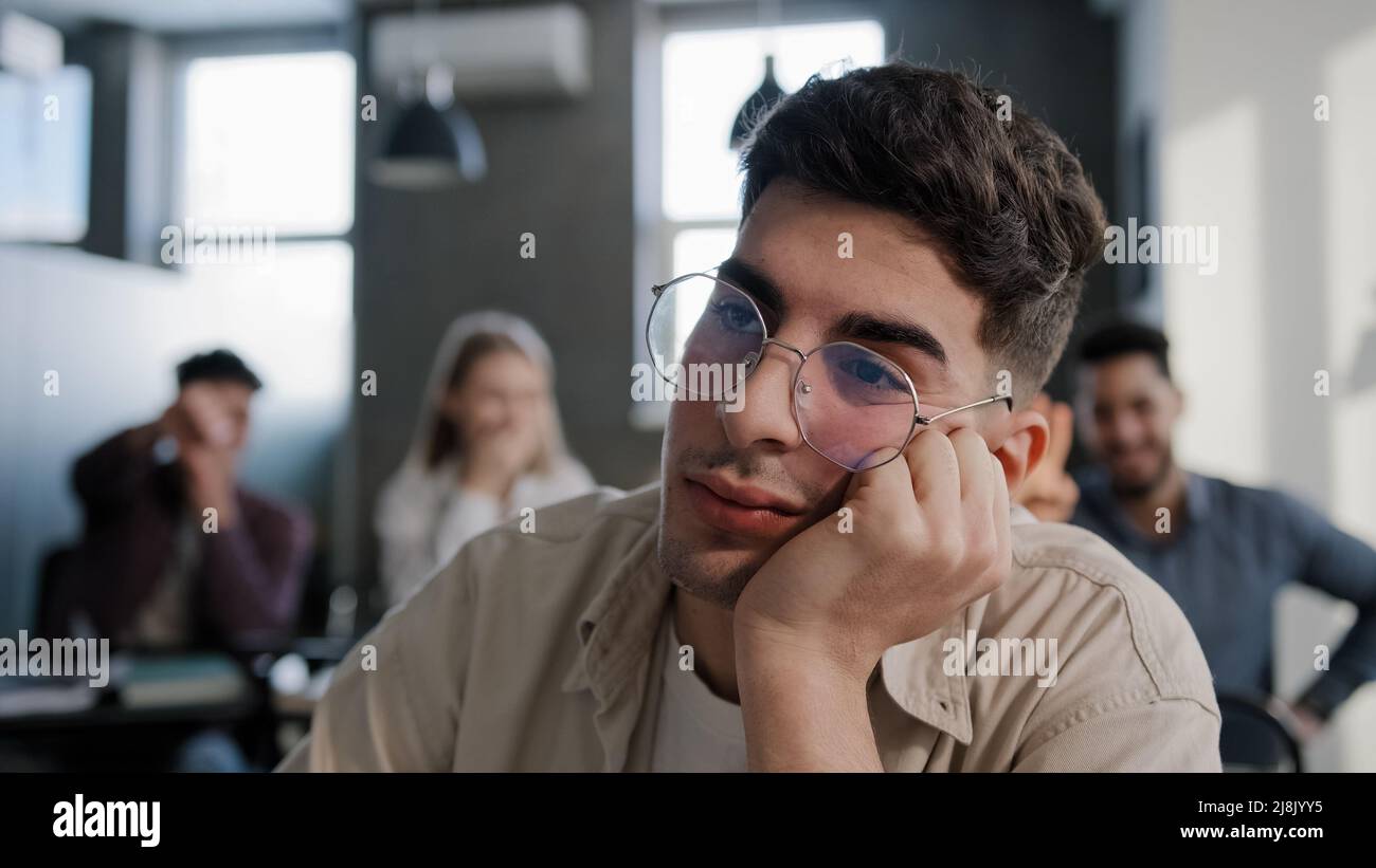 Primo piano depresso preoccupato giovane studente caucasico seduto alla scrivania da solo che soffre di maltrattamento bullismo da parte di compagni di classe ragazzo adolescente Foto Stock