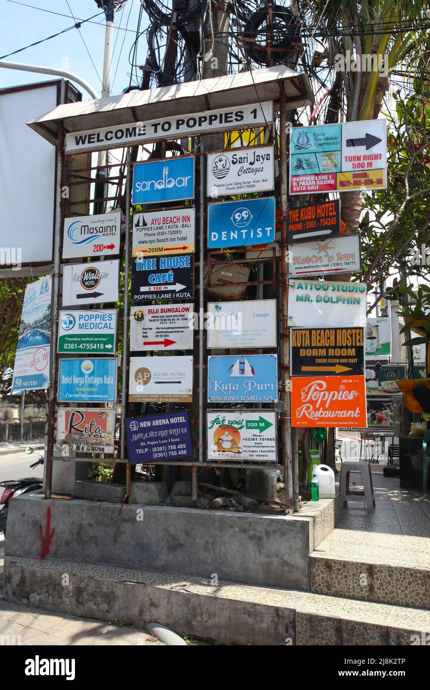 Un cartello Welcome to Poppies 1 con un elenco di hotel e aziende in Poppies Lane a Kuta, Bali, Indonesia. Foto Stock