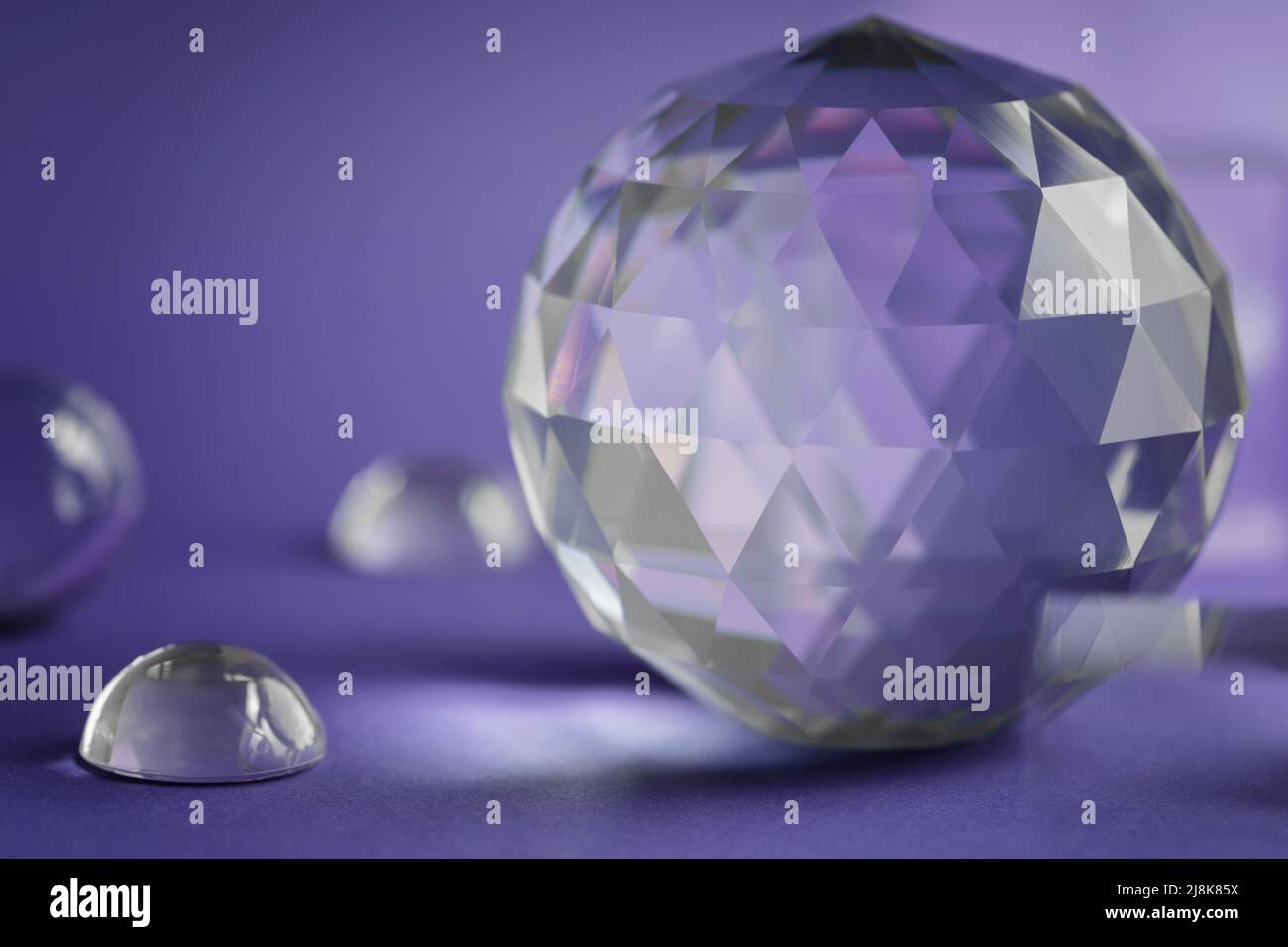 Luce rifrangente a prisma di cristallo, cristalli magici e piramide, sfera e cubo su sfondo viola. Pratica di cristallo di guarigione spirituale. Feng Shui, bravo Foto Stock