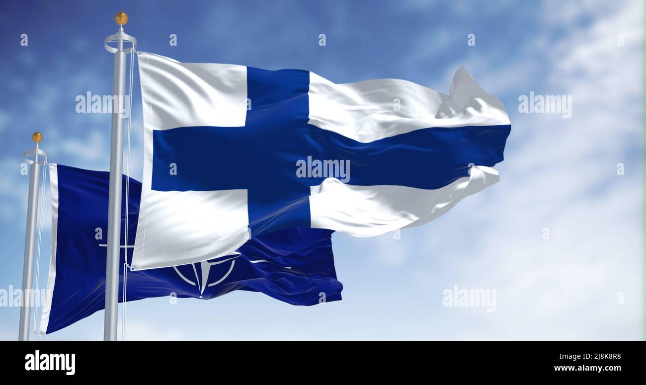 Helsinki, Finlandia, maggio 2022: La bandiera nazionale della Finlandia sventola insieme alla bandiera della NATO. Nel 2022 la Finlandia chiese di godere della NATO dopo decenni di neu Foto Stock