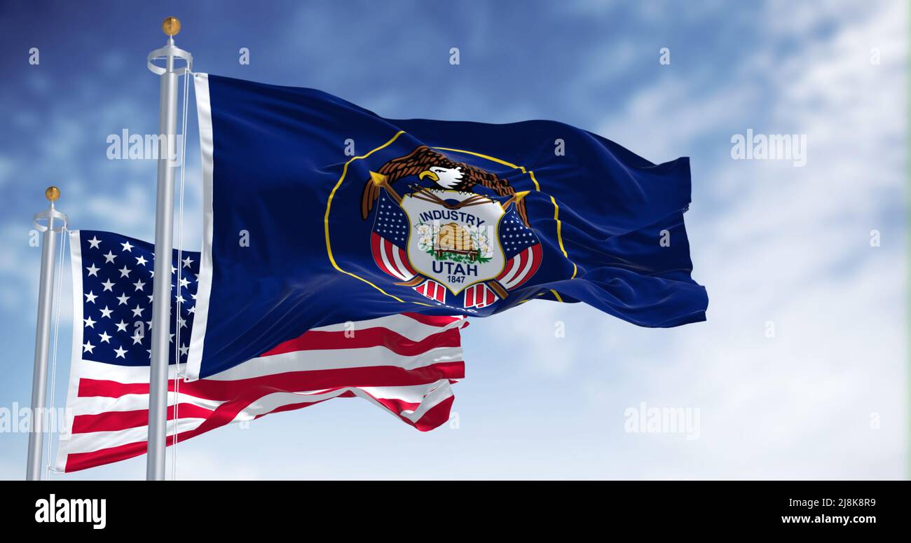 La bandiera dello stato dello Utah sventola insieme alla bandiera nazionale degli Stati Uniti d'America. Lo Utah è uno stato della regione di Mountain West Foto Stock