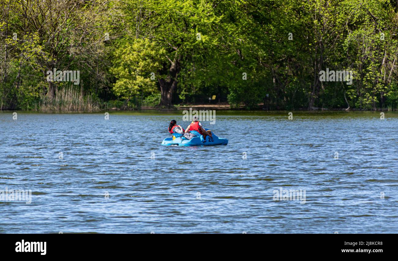 Una famiglia sul pedalò sta nuotando attraverso lo stagno nel Prospect Park primavera 2022 Foto Stock