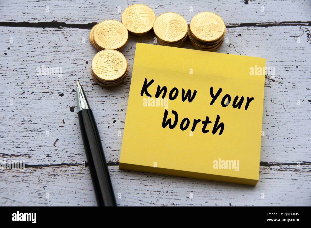 Virgolette ispiratrici e motivazionali - conosci il tuo testo degno su un blocco note giallo. Con monete d'oro e sfondo a penna. Foto Stock